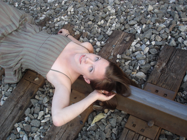 Female model photo shoot of full effect in train tracks in western PA