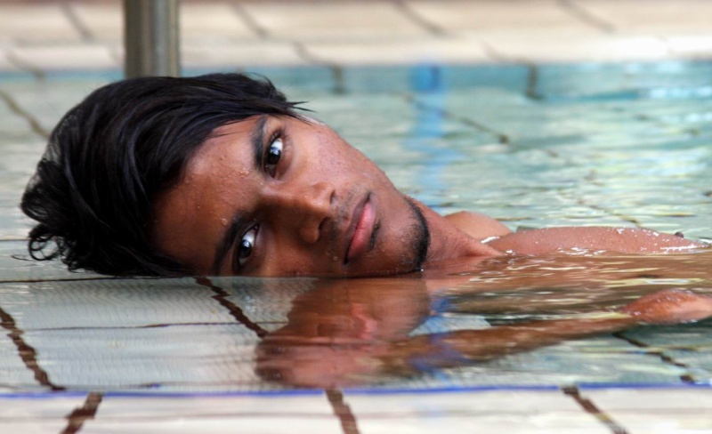 Male model photo shoot of Hariz in swimming pool, clothing designed by Edric Ong Design