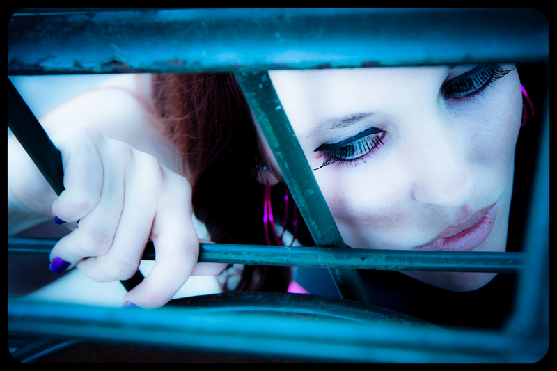 Female model photo shoot of chrystine a by pinklightimages in Behind bars