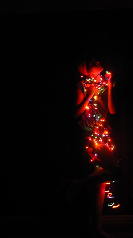 Female model photo shoot of Ashley EJ in my darkened room with some christmas lights