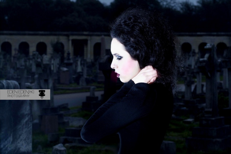 Female model photo shoot of Ally Houlli by Eden Edenski in Brompton Cemetery, hair styled by C U R L Y, makeup by Celia Wright